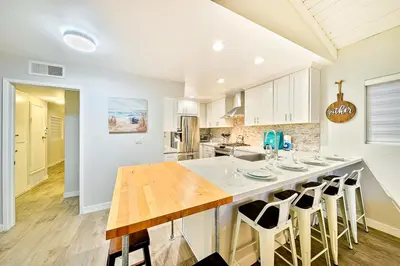 a kitchen with a large island with bar stools at 2 Story Home with Rooftop Deck next to the Bay & Beach in Newport Beach