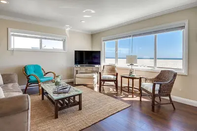 a living room with a couch and chairs and a television at Beachfront Getaway on the Sand in Newport Beach
