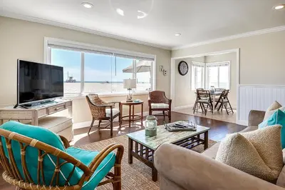 a living room with a couch and a tv at Beachfront Getaway on the Sand in Newport Beach