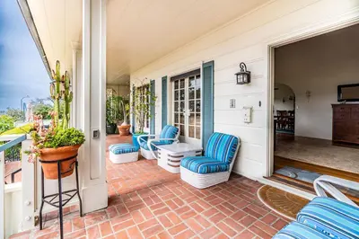 a porch with blue chairs on a house at La Jolla Shores Oceanview Retreat in San Diego