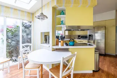 a yellow kitchen with a white table and chairs at La Jolla Shores Oceanview Retreat in San Diego