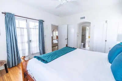 a bedroom with a white bed and blue curtains at La Jolla Shores Oceanview Retreat in San Diego