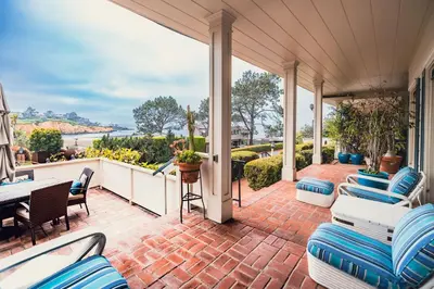an outdoor patio with chairs and a table and a balcony at La Jolla Shores Oceanview Retreat in San Diego