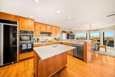 a kitchen with wooden cabinets and stainless steel appliances at Spacious Beautiful Home with Stunning Bay Views in San Diego