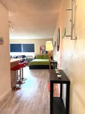 a living room with a green bed and a table at Right In The Heart Of Pacific Beach in San Diego