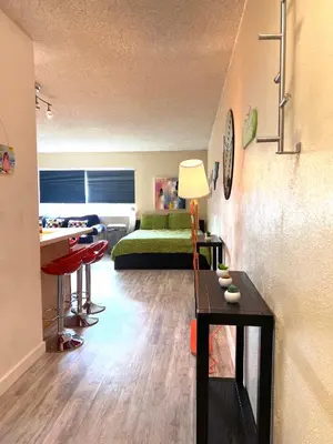 a living room with a green bed and a table at Right In The Heart Of Pacific Beach in San Diego