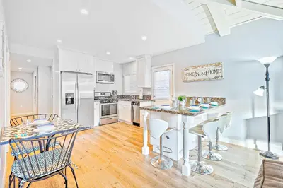 a kitchen with white appliances and a table and chairs at Cozy 3 Bedroom Across from Playground on the Beach in Newport Beach