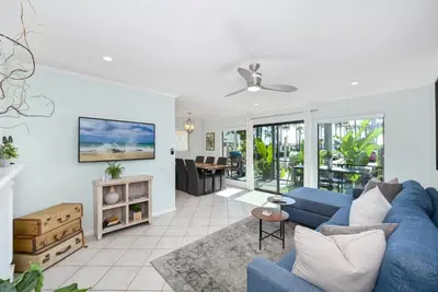 a living room with a blue couch and a fireplace at 2 Bedroom Oceanfront with Patio on the Boardwalk in Newport Beach