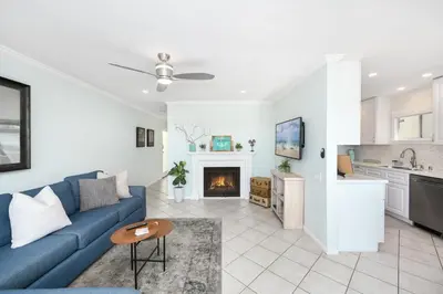 a living room with a blue couch and a fireplace at 2 Bedroom Oceanfront with Patio on the Boardwalk in Newport Beach