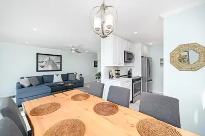 a dining room and living room with a wooden table at 2 Bedroom Oceanfront with Patio on the Boardwalk in Newport Beach