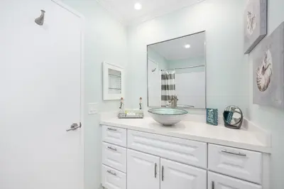 a white bathroom with a sink and a mirror at 2 Bedroom Oceanfront with Patio on the Boardwalk in Newport Beach