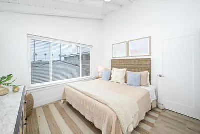 a white bedroom with a bed and a window at 6 Bedroom Duplex near the Balboa Pier and Fun Zone with AC in Newport Beach