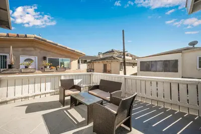 a patio with chairs and a table on a balcony at Giant Home Sleep 20, Perfect for Multi Family Vacation steps from the Sand in Newport Beach