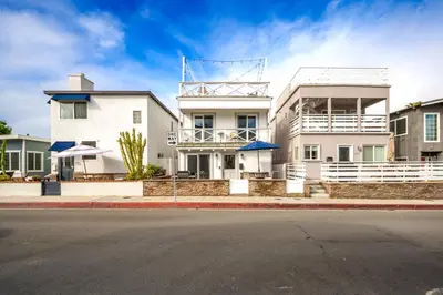 a white building on a city street at 7 Bedroom Duplex Home with Rooftop & Peek-A-Boo Ocean View in Newport Beach