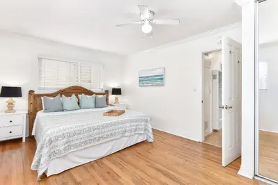 a white bedroom with a bed and a ceiling fan at 4 Bedroom Home with Rooftop & Peek-A-Boo Ocean View in Newport Beach