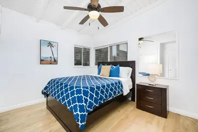 a bedroom with a bed and a ceiling fan at 5 Bedroom Duplex 1 minute Walk to the Ocean in Newport Beach