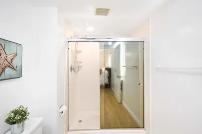 a bathroom with a shower with a glass door at Renovated 3 Bedroom Home on 41st-1 min walk to Beach in Newport Beach