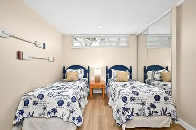 two beds in a bedroom with blue and white bedding at 5 Bedroom 4 Bath Duplex with Parking on 46th St! in Newport Beach