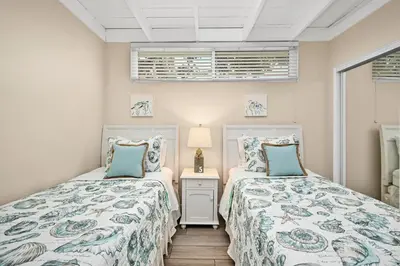 a bedroom with two beds and a table with a lamp at 5 Bedroom 4 Bath Duplex with Parking on 46th St! in Newport Beach