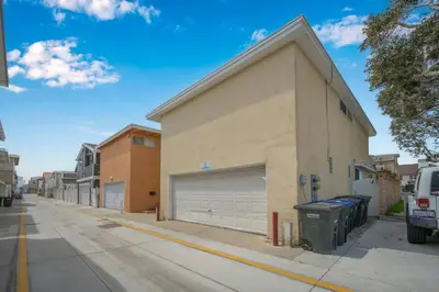 a building with two garage doors on a street at 2 Bedroom Upstairs Apt 1 block from the beach! in Newport Beach