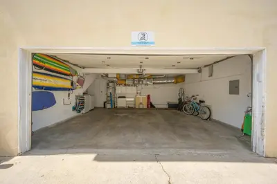 a garage with a door open to a room with surfboards at 2 Bedroom Upstairs Apt 1 block from the beach! in Newport Beach