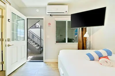 a bedroom with a bed and a door to a balcony at Duplex Across the Street from Beach & Boardwalk in Newport Beach