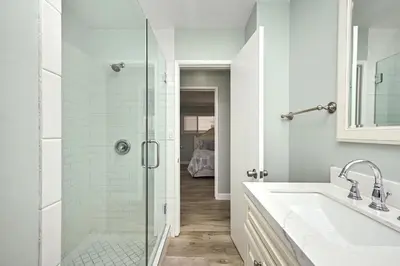a bathroom with a glass shower and a sink at Multi Level Oceanfront Home With Oceanviews and Private Patio on the Boardwalk in Newport Beach