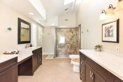 a bathroom with two sinks and a toilet and a shower at 7 Bedroom Oceanfront Home & Back House in Newport Beach
