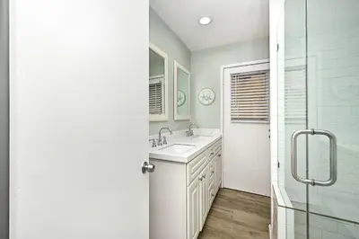 a white bathroom with a sink and a shower at Updated Home with Patio on the Boardwalk near 15th St in Newport Beach