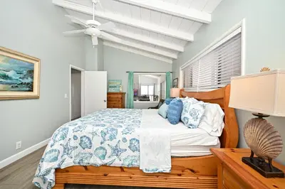 a bedroom with a bed and a ceiling fan at Oceanfront Triplex on Boardwalk with Ocean Views and Patio in Newport Beach