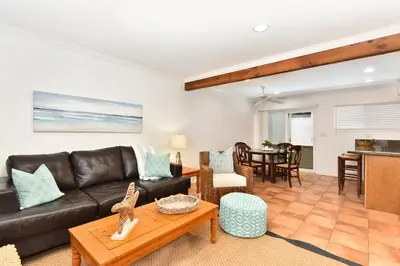 a living room with a leather couch and a table at Updated Home on the Boardwalk with Private Rear Unit in Newport Beach