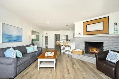 a living room with a couch and a fireplace at Updated Home on the Boardwalk with Private Rear Unit in Newport Beach