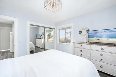 a white bedroom with a bed and a tv at Charming 2 Story and 4 Bedroom Home on the Boardwalk in Newport Beach