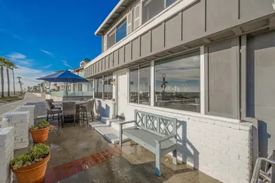 a bench sitting on the side of a building at Charming 2 Story and 4 Bedroom Home on the Boardwalk in Newport Beach