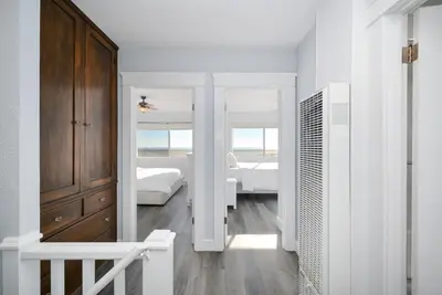 a white room with a bedroom with two beds at 5 Bedroom Duplex on the Boardwalk next to Balboa Pier in Newport Beach