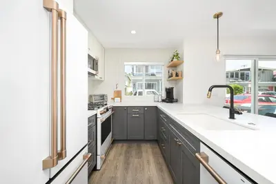 a kitchen with gray cabinets and a sink at 3 Bedroom Renovated Condo on Balboa Island in Newport Beach