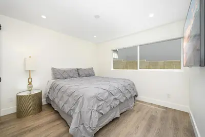 a white bedroom with a bed and a window at 3 Bedroom Renovated Condo on Balboa Island in Newport Beach