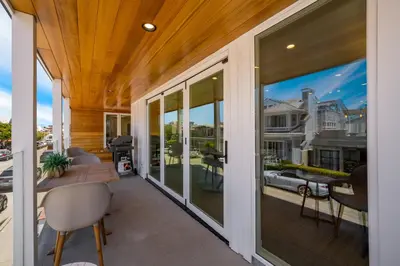 a balcony with sliding glass doors with a view of a house at 4 bedroom Renovated Home on Balboa Island in Newport Beach