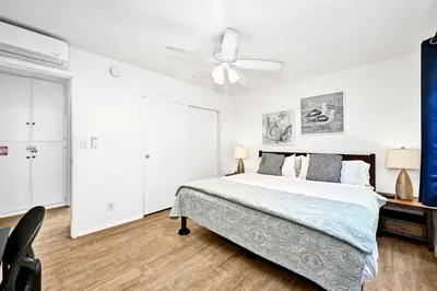 a bedroom with a bed and a ceiling fan at Spanish Castle in Newport Steps to the Sand and Grocery Store in Newport Beach