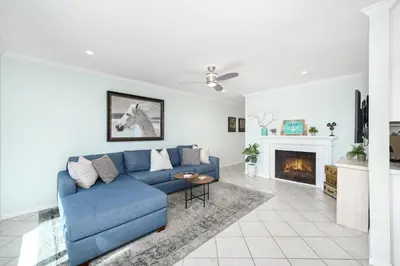 a blue couch in a living room with a fireplace at 5 Bedroom duplex with Patio & Balcony walk to Pier in Newport Beach