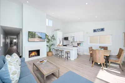 a living room with a couch and a fireplace at 5 Bedroom duplex with Patio & Balcony walk to Pier in Newport Beach