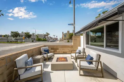a group of chairs sitting on a patio next to a building at Remodeled 4 Car with Parking Patio and Firepit in Newport Beach
