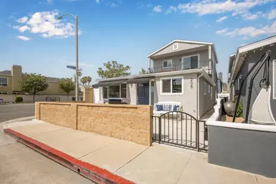 a house with a fence in front of a street at Remodeled 4 Car with Parking Patio and Firepit in Newport Beach