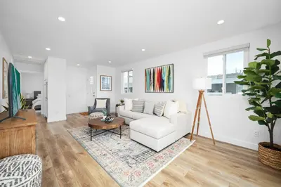 a living room with a white couch and a table at Remodeled 4 Car with Parking Patio and Firepit in Newport Beach