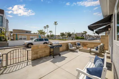 a patio with chairs and a grill on a balcony at Remodeled 4 Car with Parking Patio and Firepit in Newport Beach