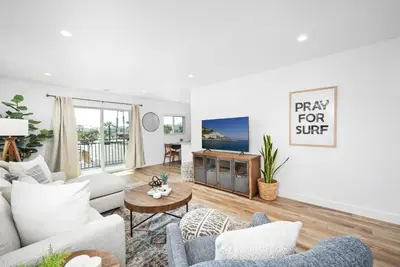 a living room with a couch and a table at Remodeled 4 Car with Parking Patio and Firepit in Newport Beach