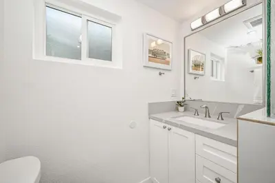 a white bathroom with a sink and a mirror at Remodeled Beach Home with 2 Car Parking Patio and Firepit in Newport Beach