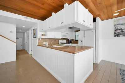 a kitchen with white cabinets and a wooden ceiling at 4 bedroom Home in Quiet Neighborhood near Beach in Newport Beach