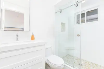 a white bathroom with a shower and a toilet at 5 Bedroom Luxury Duplex across from the Beach for 11 people in Newport Beach