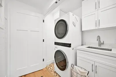 a white kitchen with a washing machine and a sink at 5 Bedroom Luxury Duplex across from the Beach for 11 people in Newport Beach